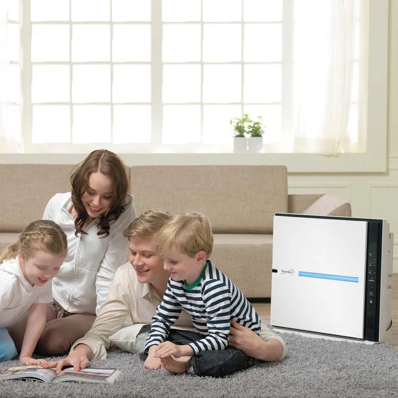 Familie sitzt auf dem Wohnzimmerboden neben dem Zepter Therapy Air iON Luftreiniger
