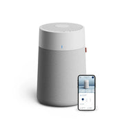 Blueair Blue Pure Max Luftreiniger mit grauem Stoffbezug und Smartphone mit zugehöriger App daneben